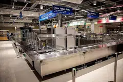 KEMUDAHAN TERSEDIA: Dewan makan utama (atas) yang akan menyajikan pelbagai pilihan makanan, termasuk halal. Atlet, yang tidak dibenarkan keluar dari Kampung Sukan kecuali ke tempat pertandingan atau pusat latihan, dikehendaki makan sendirian. Kampung sukan itu dibina untuk menampung hingga 18,000 atlet, jurulatih dan pegawai. Bilik individu sebesar 9 meter persegi, manakala bilik pasangan 12 meter persegi. - Foto AFP