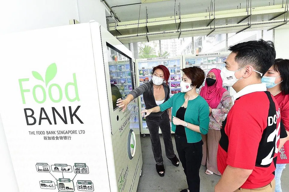 BANTU PENDUDUK MEMERLUKAN: Datuk Bandar CDC South West, Cik Low Yen Ling, dan penasihat Pertubuhan Akar Umbi GRC Chua Chua Kang (Brickland), Encik Don Wee, semasa melancarkan mesin layan diri bank makanan di Blok 813A, Choa Chu Kang Avenue 7 pada Sabtu lalu. - Foto oleh CDC SOUTH WEST