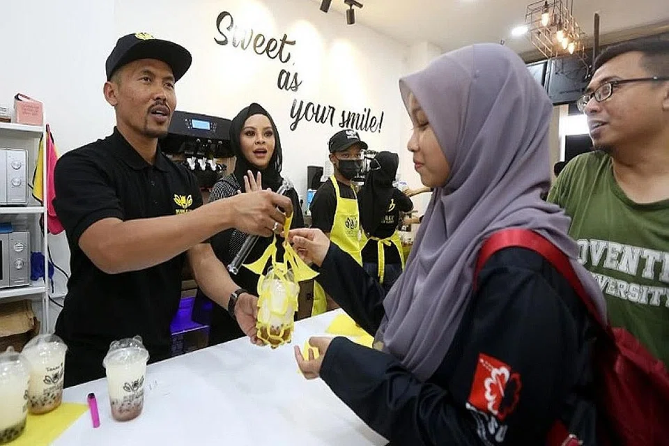 GIGIH BANGUN PERNIAGAAN: Shuib Sepahtu (kiri) dibantu isteri Siti Sarah Raisuddin (dua dari kiri) ingin mengembangkan lagi perniagaan minuman 'bubble tea' Bubblebee, lantas mengambil keputusan memperlahankan kerjaya seninya. - Foto KOPI PLANET