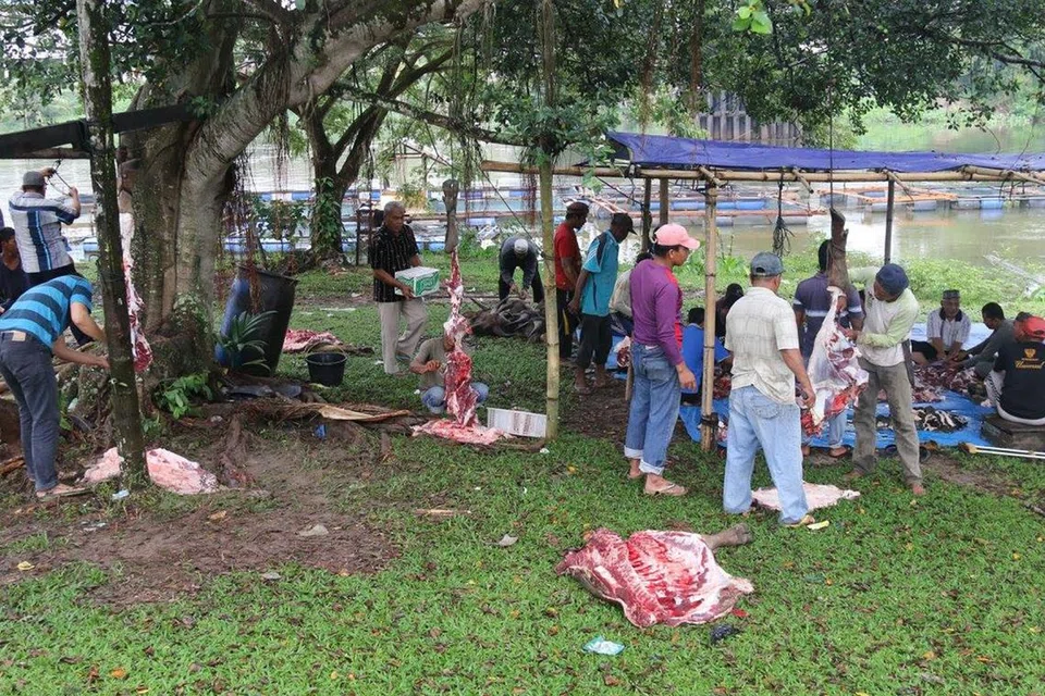 GOTONG ROYONG: Orang kampung sama-sama melapah dan memotong kerbau setelah ia disembelih di Kuok, Riau, Indonesia pada tahun 2017.