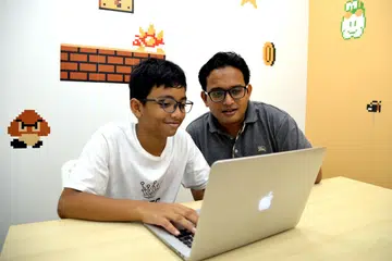SOKONGAN KUAT: Encik Mohamad Faiz Selamat (kanan) mahu mendedahkan anaknya, Amir Irfaan, kepada pengekodan dengan lebih mendalam. Pada Januari lalu, beliau mendaftarkan Irfaan bagi mengikuti kursus pemprograman komputer di First Code Academy. - Foto SHAKIR SAIFUDDIN