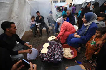 SEDIAKAN MAKANAN: Rakyat Palestin yang lari daripada pengeboman Israel kini hidup di khemah sementara di Khan Yunis, selatan Gaza.  
