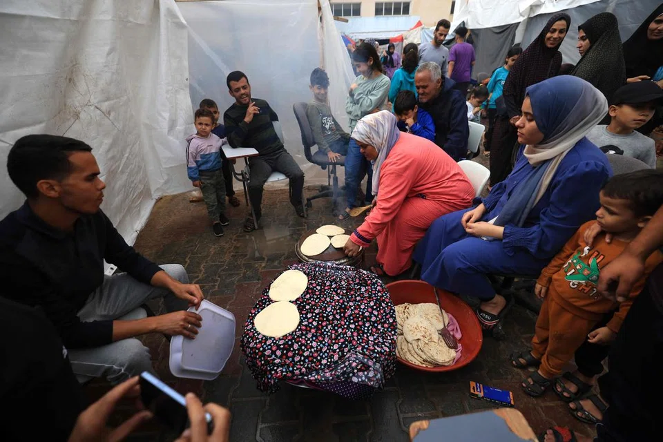 SEDIAKAN MAKANAN: Rakyat Palestin yang lari daripada pengeboman Israel kini hidup di khemah sementara di Khan Yunis, selatan Gaza.  