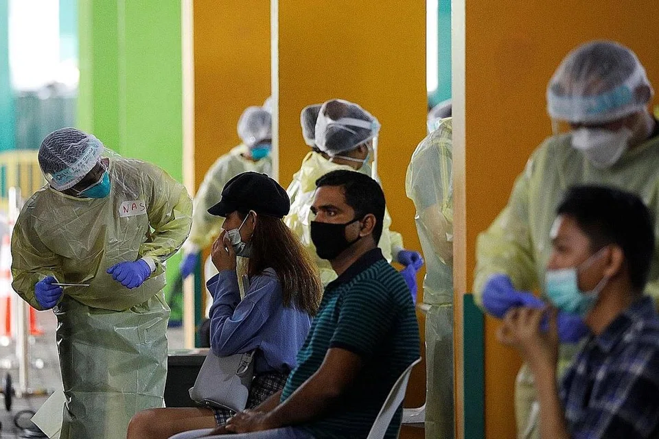 KAWAL PENULARAN: Pekerja di Singapura perlu menjalani ujian swab Covid-19 sebelum dibenarkan kembali bertugas. - Foto REUTERS