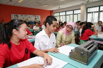 INKLUSIVITI DI SEKOLAH: Presiden Halimah Yacob berinteraksi dengan seorang pelajar kurang daya penglihatan, Lawrence Gabriel V. Angel, semasa lawatannya ke Sekolah Menengah Ahmad Ibrahim pada 2019. 