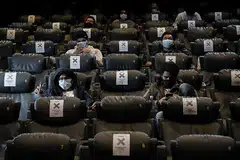 GUNAKAN PELITUP DI PAWAGAM: Penonton mengenakan pelitup muka dan dalam masa yang sama mematuhi arahan jarak selamat semasa menonton filem di Golden Screen Cinemas, selepas pawagam dibuka semula di Kuala Lumpur baru-baru ini. - Foto REUTERS