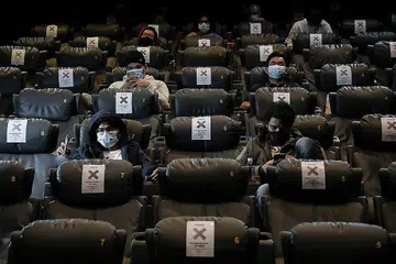 GUNAKAN PELITUP DI PAWAGAM: Penonton mengenakan pelitup muka dan dalam masa yang sama mematuhi arahan jarak selamat semasa menonton filem di Golden Screen Cinemas, selepas pawagam dibuka semula di Kuala Lumpur baru-baru ini. - Foto REUTERS