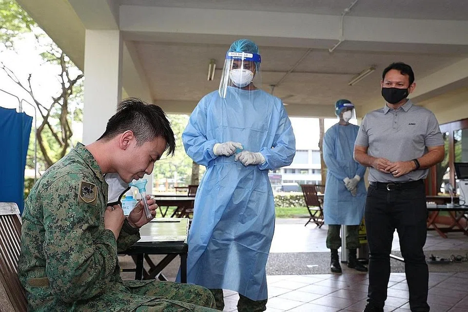 PERHATIKAN UJIAN DIJALANKAN: Encik Zaqy (kanan) melihat ujian DTS dilakukan ke atas anggota NS di Kem Jurong semalam. - Foto BH oleh TIMOTHY DAVID