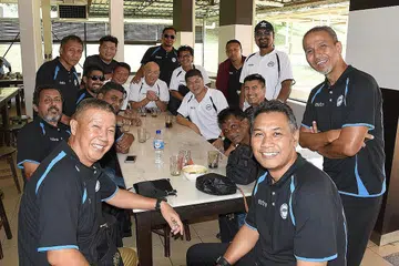 SEDIA BERSAING: Sebahagian pemain veteran Singapura (atas) menjamu selera ketika berhenti rehat di R&R Pagoh sebelum ke Shah Alam. Pilihan Singapura terdiri daripada 21 pemain, termasuk empat pemain asing, dari tujuh pasukan Liga Perdana Singapura (SPL). - Foto ZAINAL YAHYA