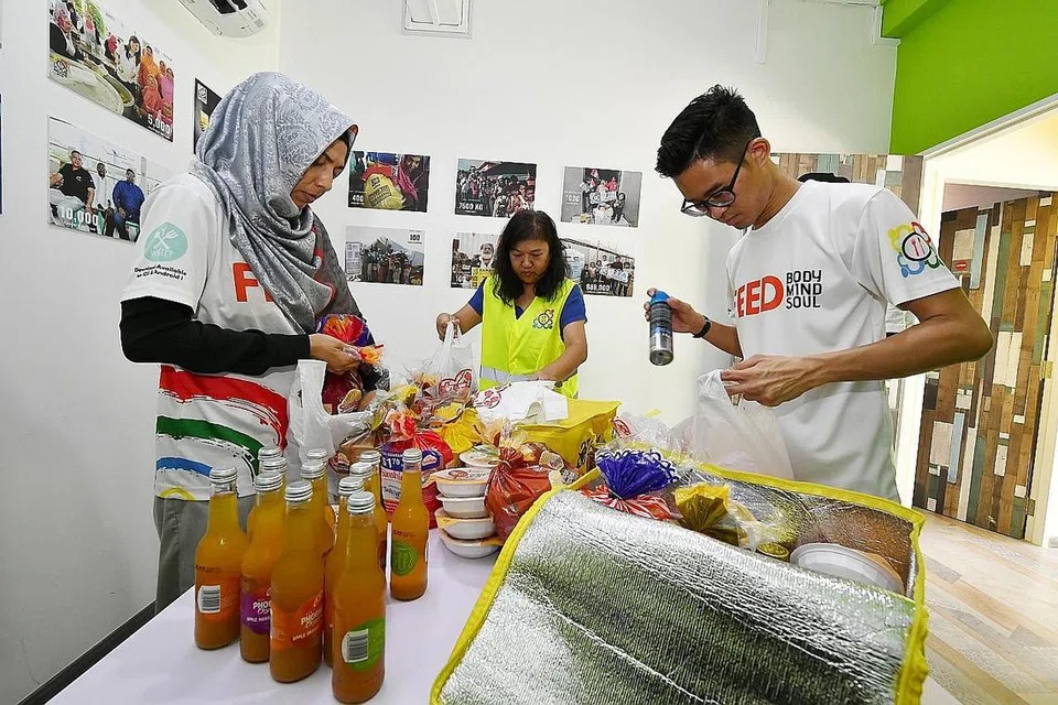 GOTONG ROYONG: Kakitangan Free Food For All membungkus barangan untuk diagihkan kepada golongan memerlukan, termasuk makanan berkhasiat untuk membantu golongan itu menjaga kesihatan mereka. Gambar diambil sebelum arahan pemutus litar diperkenalkan. - Foto fail