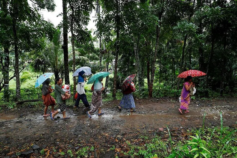 BEKALAN BANTUAN: Penduduk tempatan yang terjejas berjalan ke arah pusat perlindungan dengan bekalan bantuan yang mereka baru terima menyusuli tsunami.