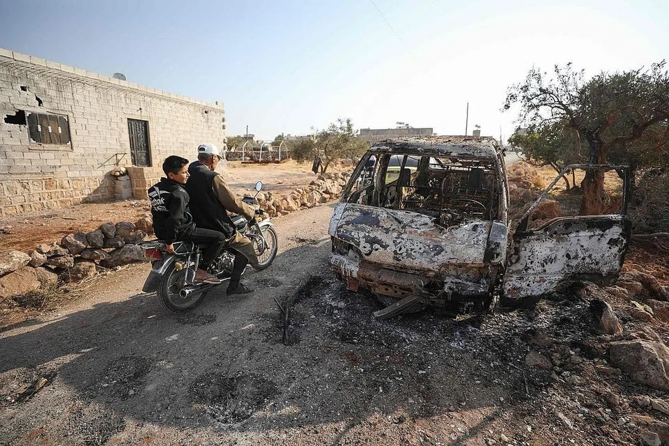 KESAN SERANGAN: Warga Syria menunggang motosikal berdekatan kawasan serangan helikopter yang menyasarkan sebuah kereta dan rumah di wilayah Idlib yang dipercayai didiami "kumpulan berkaitan dengan ISIS". Dalam operasi tentera elit Amerika itu juga, pemimpin ISIS, Abu Bakr al-Baghdadi, dilaporkan meledakkan jaket bunuh dirinya. - Foto AFP