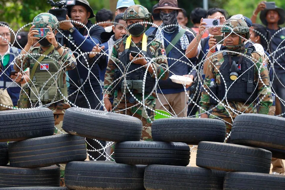 Pasukan keselamatan Kemboja dan penduduk kampung berdiri di belakang pagar kawat berduri berhadapan pegawai Thailand yang berkawal di sempadan Thailand-Kemboja di Ban Nong Ya Kaeo, wilayah Sa Kaeo, Thailand, 19 September 2025. Tentera Diraja Thailand membawa media tempatan dan antarabangsa melawat kawasan sempadan yang dipertikaikan selepas pasukan Thai bertempur dengan penunjuk perasaan Kemboja yang cuba menanggalkan kawat berduri menggunakan gas pemedih mata, peluru getah dan alat bunyi. Pihak Kemboja mendakwa sekurang-kurangnya 28 orang cedera dan menuduh Thailand melanggar gencatan senjata Julai, manakala Thailand menegaskan tindakan itu adalah mempertahankan diri.