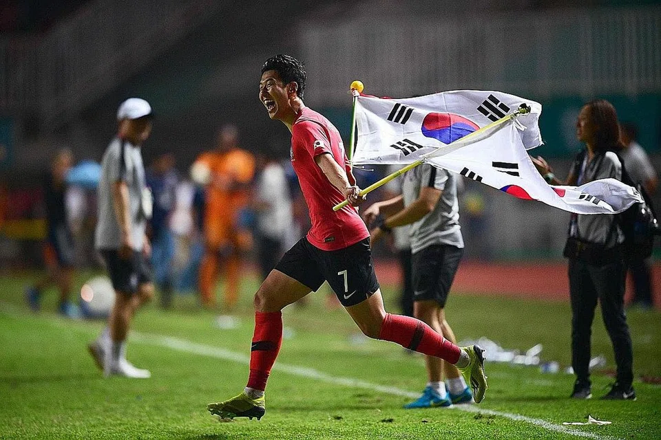 RIANG: Pemain bola sepak Korea Selatan Son Heung-min tidak dapat membendung kegembiraan di wisel penamat final acara bola sepak di Bogor dan berlari ke arah rakan sepasukannya di padang. Korea Selatan memenangi pingat emas selepas mengalahkan Jepun 2-1 di final. - Foto AFP