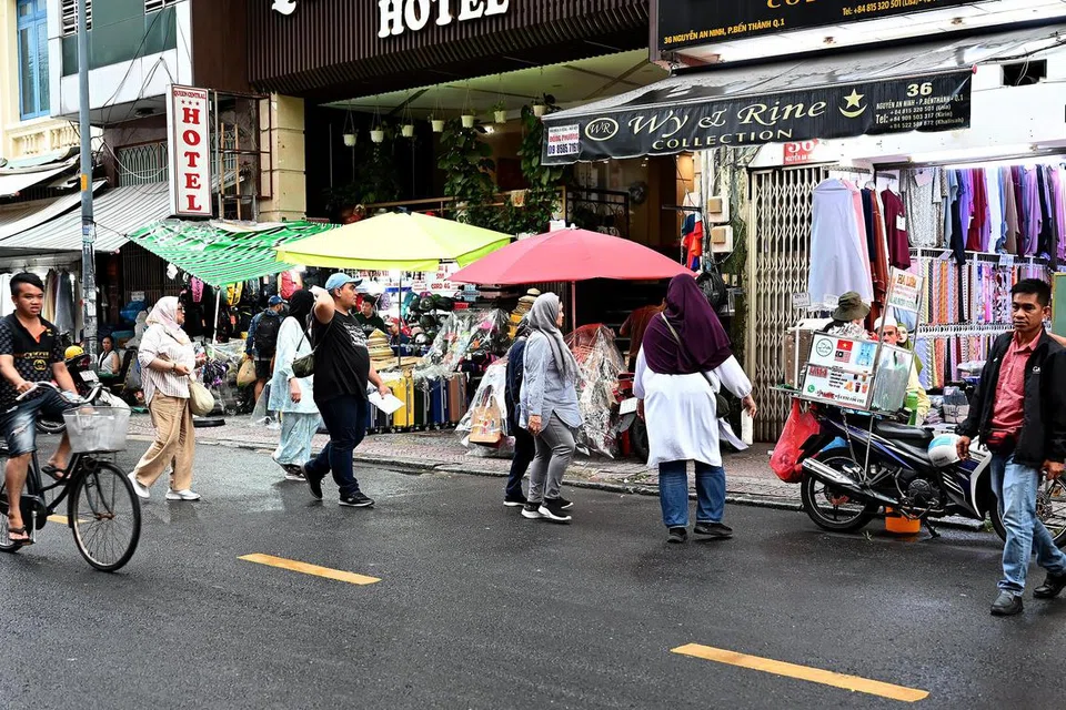 Pelancong di Malaysia Street, Ho Chi Minh, dengan pelbagai pilihan tudung dan telekung serta sajian makanan Halal. 