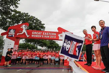 ACARA LARI BERAMAI-RAMAI: (Dari kiri di atas pentas) Encik Khor, Cik Fu dan Encik Lim melancarkan permulaan acara lari beramai-ramai Great Eastern Women's Run bagi kategori 10 kilometer. - Foto GREAT EASTERN WOMEN'S RUN