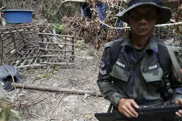 TEMPAT KURUNGAN: Menurut polis Malaysia, sangkar yang diperbuat daripada dawai berduri dan buluh kayu ini digunakan untuk menahan pendatang asing di Bukit Wang Burma. - Foto REUTERS