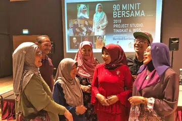 BERSAMA PEMINAT: Junainah (berbaju merah) beramah tamah dengan para peminatnya semasa sesi '90 Minit Bersama...' di Wisma Geylang Serai pada Jumaat lalu. - Foto BM oleh ISMAWATI ISMAIL