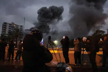Penduduk dan media menyaksikan serangan udara Israel ke atas sebuah bangunan di daerah Chiyah, pinggir bandar di selatan Beirut, Lebanon, pada 25 November.