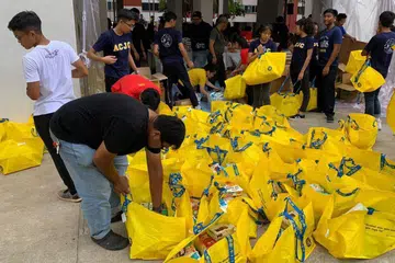GOTONG-ROYONG: Belia-belia menyumbang tenaga membungkus hamper-hamper yang akan diagihkan sebagai sebahagian program ROW tahun ini. - Foto PERSATUAN PERSURATAN PEMUDA-PEMUDI MELAYU (4PM)