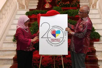 LOGO BARU: Presiden Halimah Yacob dan suaminya, Encik Mohamed Abdullah Al-Habshee, melancarkan logo dan visi baru Cabaran Presiden semasa rumah terbuka Istana sempena Tahun Baru Cina Ahad lalu. - Foto BH oleh KHALID BABA