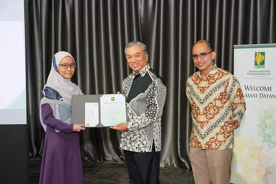SAMPAIKAN SUMBANGAN: Mantan Presiden Lembaga Biasiswa Kenangan Maulud (LBKM), Encik Suhaimi Salleh (tengah), bersama Presiden LBKM terkini, Dr Syed Harun Alhabsyi (kanan), menyampaikan sumbangan kepada salah seorang penerima dalam Majlis Anugerah Madrasah LBKM 2022.