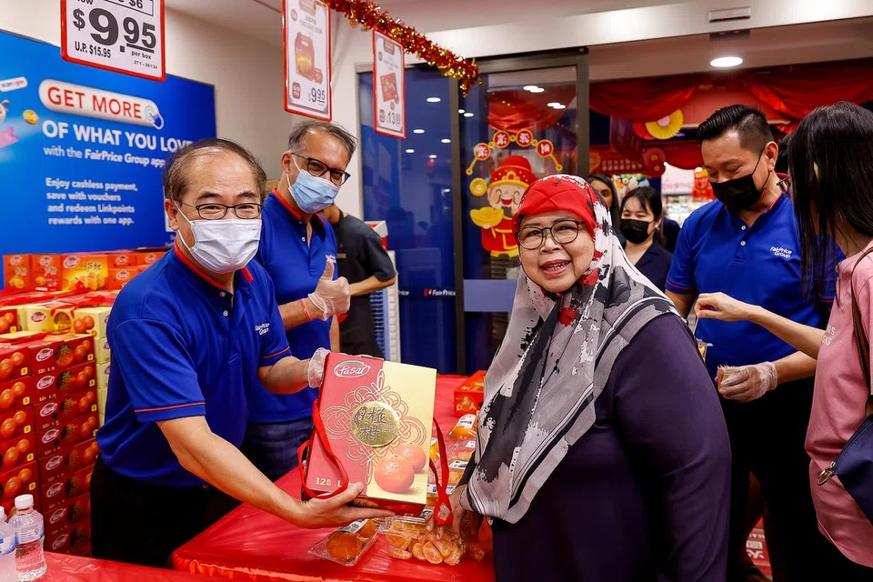 (Dari kiri) Pengerusi FairPrice Group (FPG), Encik Kee Teck Koon, dan CEO FPG, Encik Vipul Chawla, berkongsi bersama pelanggan pasar raya FairPrice di cawangan Kampung Admiralty mengenai promosi limau mandarin.