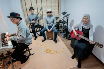 Band Zelotones yang terdiri daripada empat anggota kurang upaya mula bermain muzik bersama sejak 2017 dan menyewa studio untuk berlatih. Namun, sejak 2023 mereka dapat berlatih di rumah pasangan suami isteri, Zyana (kanan) dan Alex (dua dari kanan) yang dilengkapi ruang studio sendiri. Ben (kiri) dan Zach adalah dua anggota lain Zelotones.