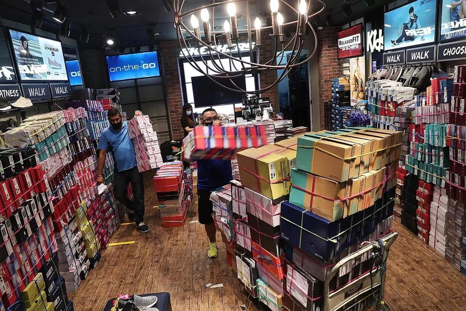SIAP UNTUK SAMBUT SEMULA PELANGGAN: Pekerja di kedai kasut Skechers di Clementi Mall sibuk memindahkan kotak bagi menyusun semula kedai itu bagi manyambut semula pelanggan esok. - Foto BH oleh KELVIN CHNG