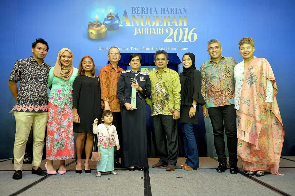 KELUARGA TUNGGAK SOKONGAN: Cik Zuraidah (tengah) bersama anggota keluarganya yang turut hadir di majlis jamuan Anugerah Jauhari Berita Harian malam kelmarin. - Foto M.O. SALLEH