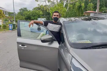 REDA DENGAN KEADAAN: Meskipun terpaksa menghantar barangan dari Loyang ke Jurong West, Encik Faizal tetap bersikap positif demi menyara keluarganya termasuk orang tuanya yang menghidap penyakit kronik. - Foto ihsan MOHAMMAD FAIZAL ABDUL LATIFF