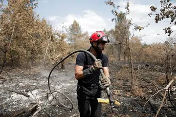 USAHA PADAMKAN API: Seorang anggota bomba cuba memadamkan kebakaran tanah di Landiras, di wilayah Gironde, Perancis. Gelombang haba yang melanda Eropah mengakibatkan lebih 1,700 kematian di Semenanjung Iberian setakat ini. - Foto-foto REUTERS, AFP