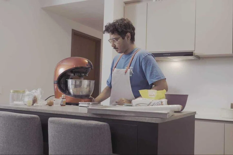 Penulis memeriksa adunan doh yang sedang digaul menggunakan pengadun elektrik bagi memastikan ia sebati ketika mencuba menyediakan tart nanas berpandukan resipi yang dicadangkan oleh kecerdasan buatan (AI).