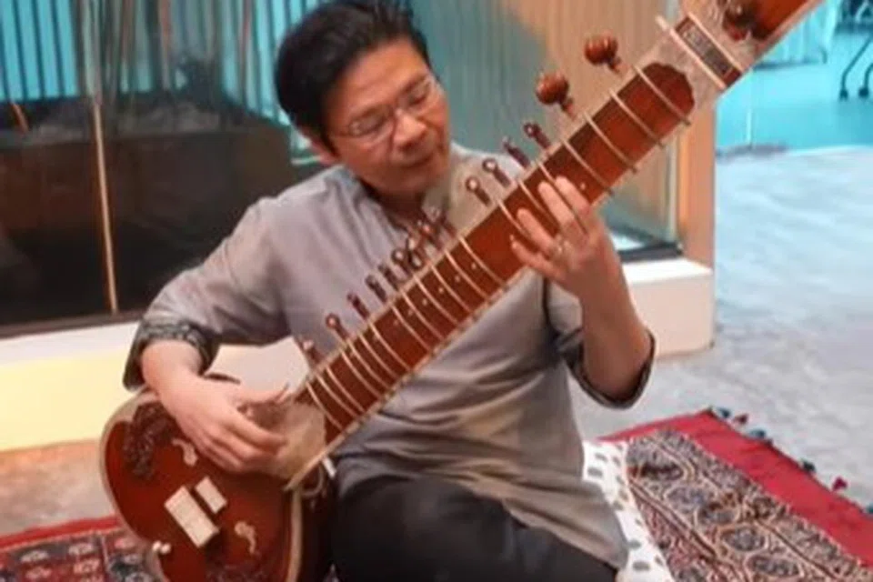 BERMAIN MUZIK: Timbalan Perdana Menteri, Encik Lawrence Wong, belajar cara bermain alat muzik bertali India, sitar. 