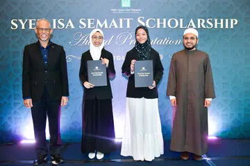 BIASISWA BERPRESTIJ: (Dari kiri) Encik Masagos Zulkifli Masagos Mohamad, serta dua penerima biasiswa - Cik Haninah Rehan dan Cik Siti Nur Fatimah Abdul Rashid - bersama Dr Nazirudin Mohd Nasir di majlis penyampaian Biasiswa Syed Isa Semait pada Isnin.