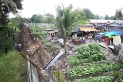 MEMERIKSA: Pegawai penjara (kiri) memeriksa pagar penjara setelah lebih 130 banduan melarikan diri dari penjara yang terletak di Kidapawan di bahagian selatan Mindanao semalam ketika militan menyerang penjara tersebut dan membunuh seorang pegawai. - Foto AFP