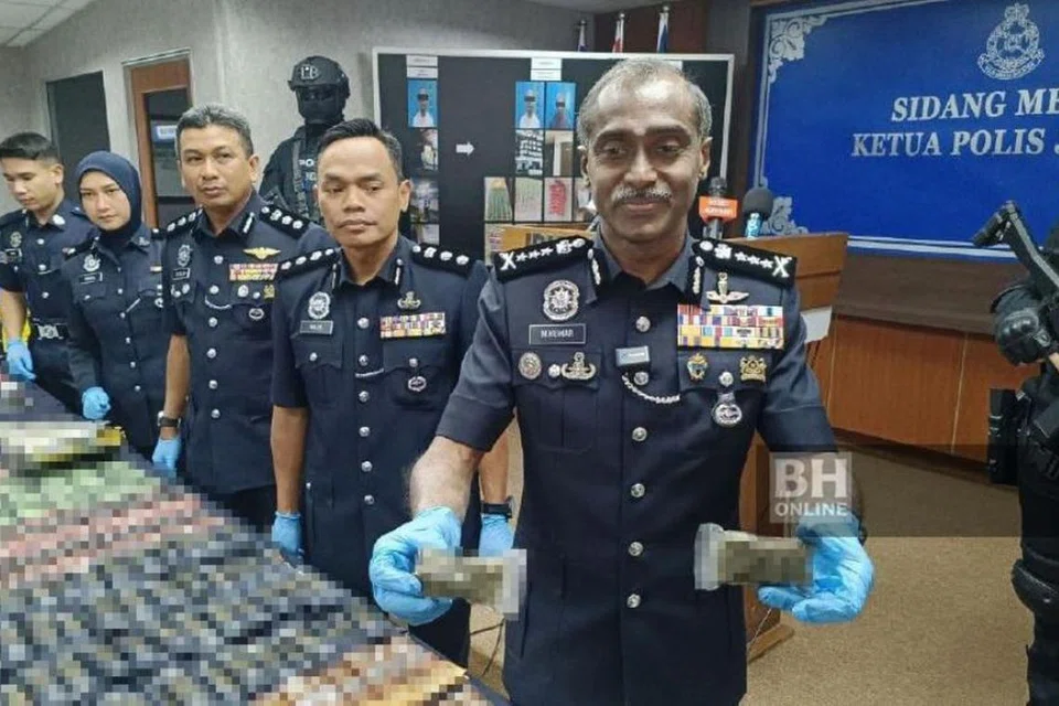 Ketua Polis Johor, Datuk M Kumar (depan), menunjukkan pelbagai jenis dadah bernilai RM3.2 juta ($970,000) yang dirampas menerusi tujuh serbuan terhadap sindiket pengedaran dadah sekitar Johor Bahru.