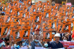 BEBASKAN PEMIMPIN KAMI: Penunjuk perasaan memegang poster Cik Suu Kyi supaya membebaskan pemimpin demokrasi negara itu daripada hukuman penjara. - Foto-foto AFP