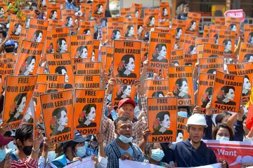 BEBASKAN PEMIMPIN KAMI: Penunjuk perasaan memegang poster Cik Suu Kyi supaya membebaskan pemimpin demokrasi negara itu daripada hukuman penjara. - Foto-foto AFP