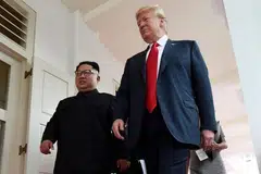 SAAT BERSEJARAH: Encik Trump (kanan) dan Encik Kim berjalan di Hotel Capella, selepas bersemuka buat kali pertama pada 12 Jun.