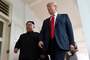 SAAT BERSEJARAH: Encik Trump (kanan) dan Encik Kim berjalan di Hotel Capella, selepas bersemuka buat kali pertama pada 12 Jun.