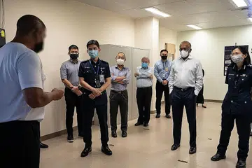 BANTU PESALAH BANGKIT SEMULA: Encik Shanmugam (dua dari kanan) mendengar perkongsian banduan di Kompleks Selarang Park semasa lawatannya di sana semalam. - Foto SINGAPORE PRISON SERVICE