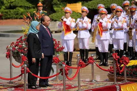 KERJASAMA PERKUKUH KEDUDUKAN ASEAN: Singapura dan Vietnam akan mengusahakan ke arah penubuhan grid tenaga Asean serta kerjasama ekonomi hijau dan digital. Gambar menunjukkan Presiden Halimah dan Presiden Nguyen Xuan Phuc semasa majlis sambutan yang diadakan di Istana Presiden pada hari pertama lawatannya ke Vietnam. - Foto EPA-EFE