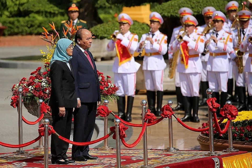 KERJASAMA PERKUKUH KEDUDUKAN ASEAN: Singapura dan Vietnam akan mengusahakan ke arah penubuhan grid tenaga Asean serta kerjasama ekonomi hijau dan digital. Gambar menunjukkan Presiden Halimah dan Presiden Nguyen Xuan Phuc semasa majlis sambutan yang diadakan di Istana Presiden pada hari pertama lawatannya ke Vietnam. - Foto EPA-EFE