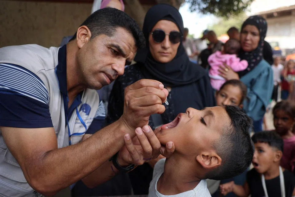 Seorang pekerja kesihatan memberi vaksin polio kepada seorang kanak-kanak Palestin di Zawayda di Jaluran Gaza pada 1 September 2024 setelah Israel bersetuju bagi “gencatan kemanusiaan” di beberapa bahagian di Gaza selama tiga hari bermula pada 31 Ogos untuk memudahkan  vaksinasi.