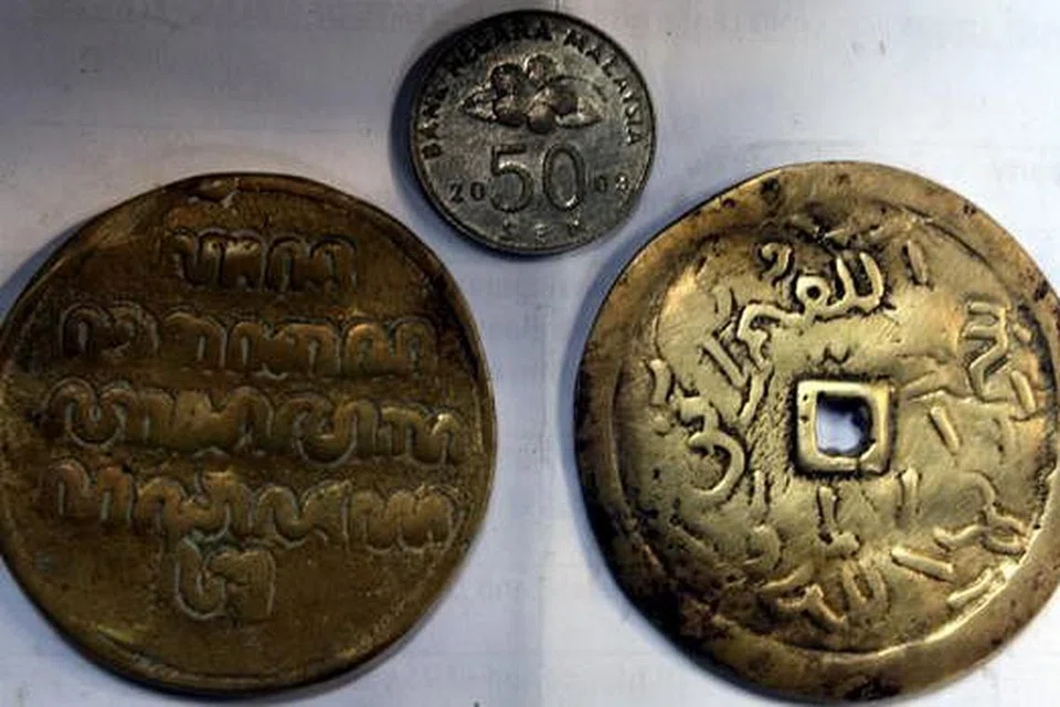 TANDA HARTA KARUN?: Kepingan logam seperti dua keping syiling besar ini, (berbanding syiling 50 sen Malaysia), ditemui sedang pekerja menggerudi sebuah tembok gua untuk mencari khazanah tersebut. - Foto THE STAR PUBLICATION