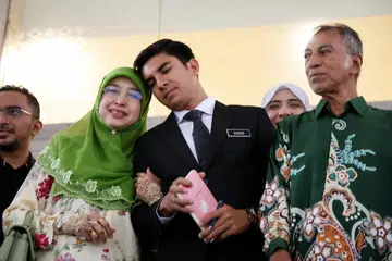 Syed Saddiq Syed Abdul Rahman (tengah) bersama ibunya, Sharifah Mahani Syed Abdul Aziz.