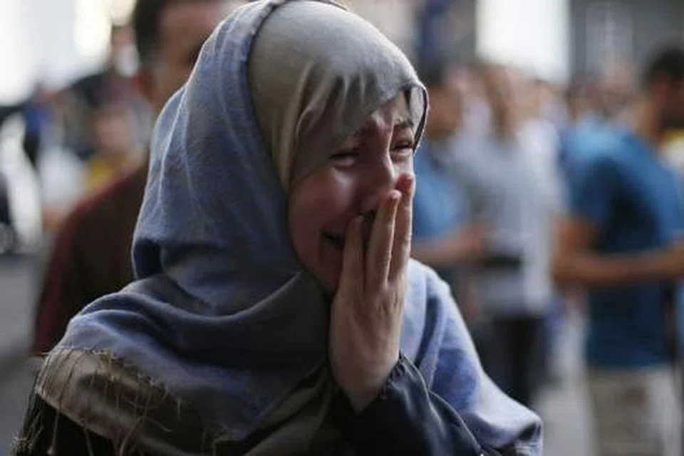 RAUNGAN PILU: Saudara kepada seorang rakyat Palestin yang terbunuh dalam serangan Israel di pasar di Shejaia, meratap di hospital di Gaza City. Israel lancarkan pengeboman dekat sebuah pasar di timur Gaza mengorbankan 15 warga Palestin kelmarin. - Foto REUTERS