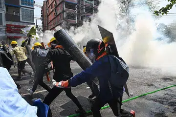 MASIH BERGOLAK: Para penunjuk perasaan di Yangon lari apabila gas pemedih mata dilemparkan bagi memaksa mereka bersurai dalam bantahan semalam. - Foto AFP
