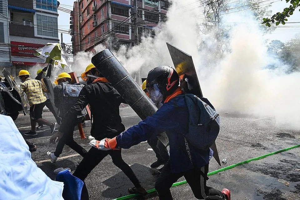 MASIH BERGOLAK: Para penunjuk perasaan di Yangon lari apabila gas pemedih mata dilemparkan bagi memaksa mereka bersurai dalam bantahan semalam. - Foto AFP